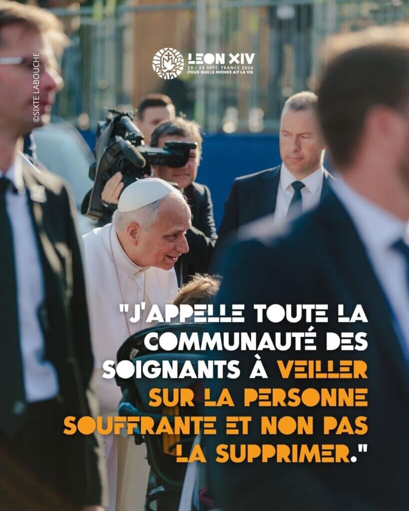 Le Pape Léon penché sur une personen en fauteuil roulant.